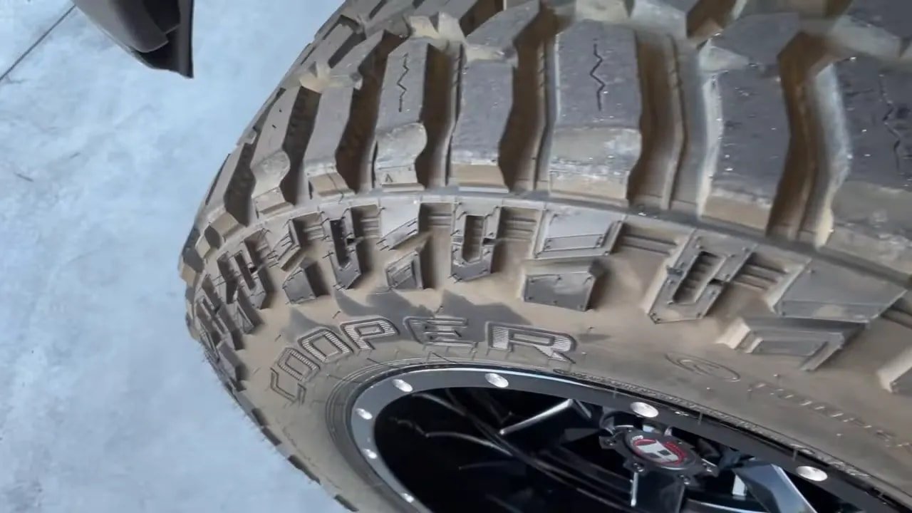 Close-up of aggressive mud-terrain tire tread blocks and sidewall