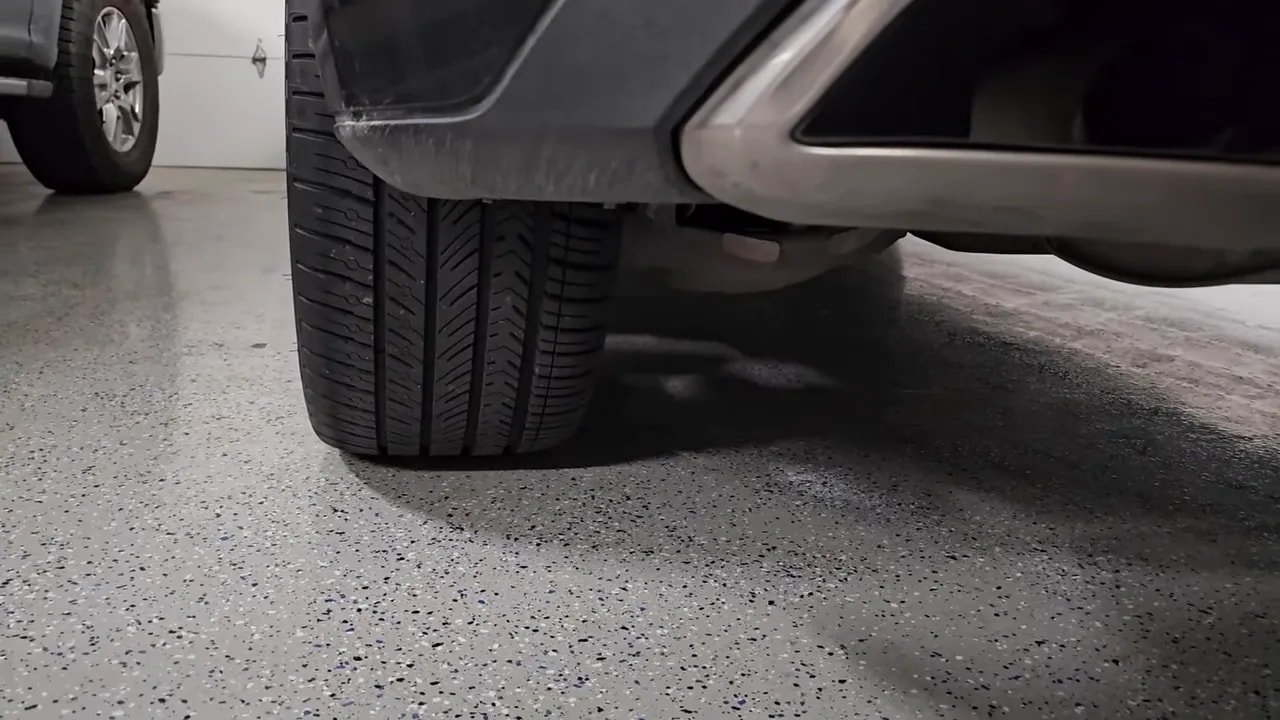 All-season tire on wet concrete with visible tread blocks