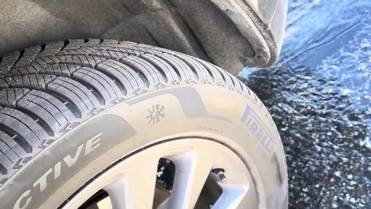 All-season tire tread close-up with snowflake symbol and wet-road style grooves screenshot