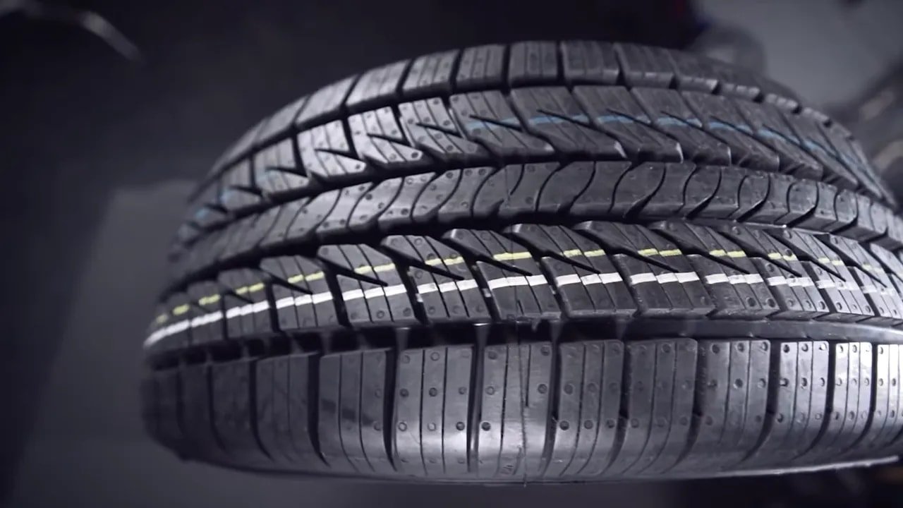 Detailed close-up of all-season tire tread grooves and sipes