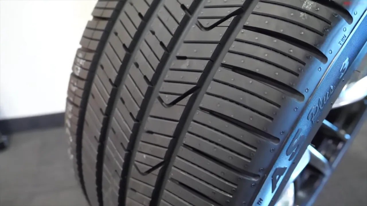 All-season tire tread close-up with water droplets illustrating wet traction features