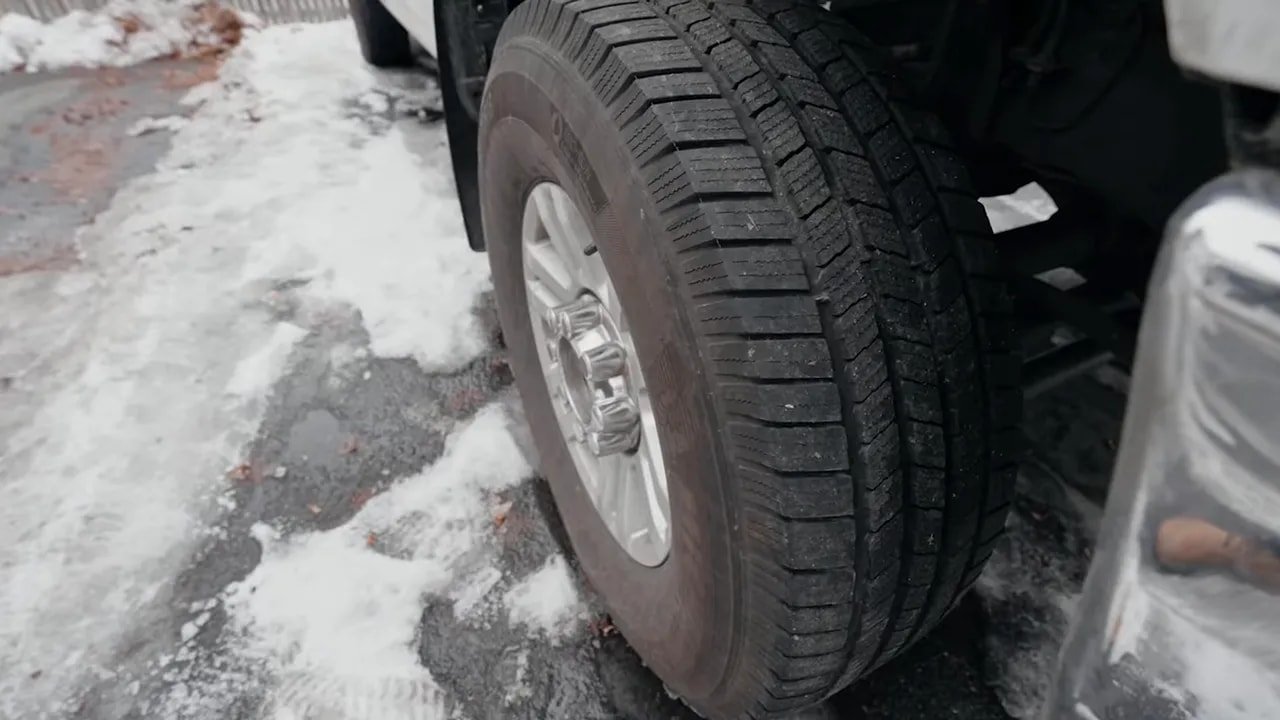 Close-up of a truck SUV tire with tread in snowy weather conditions