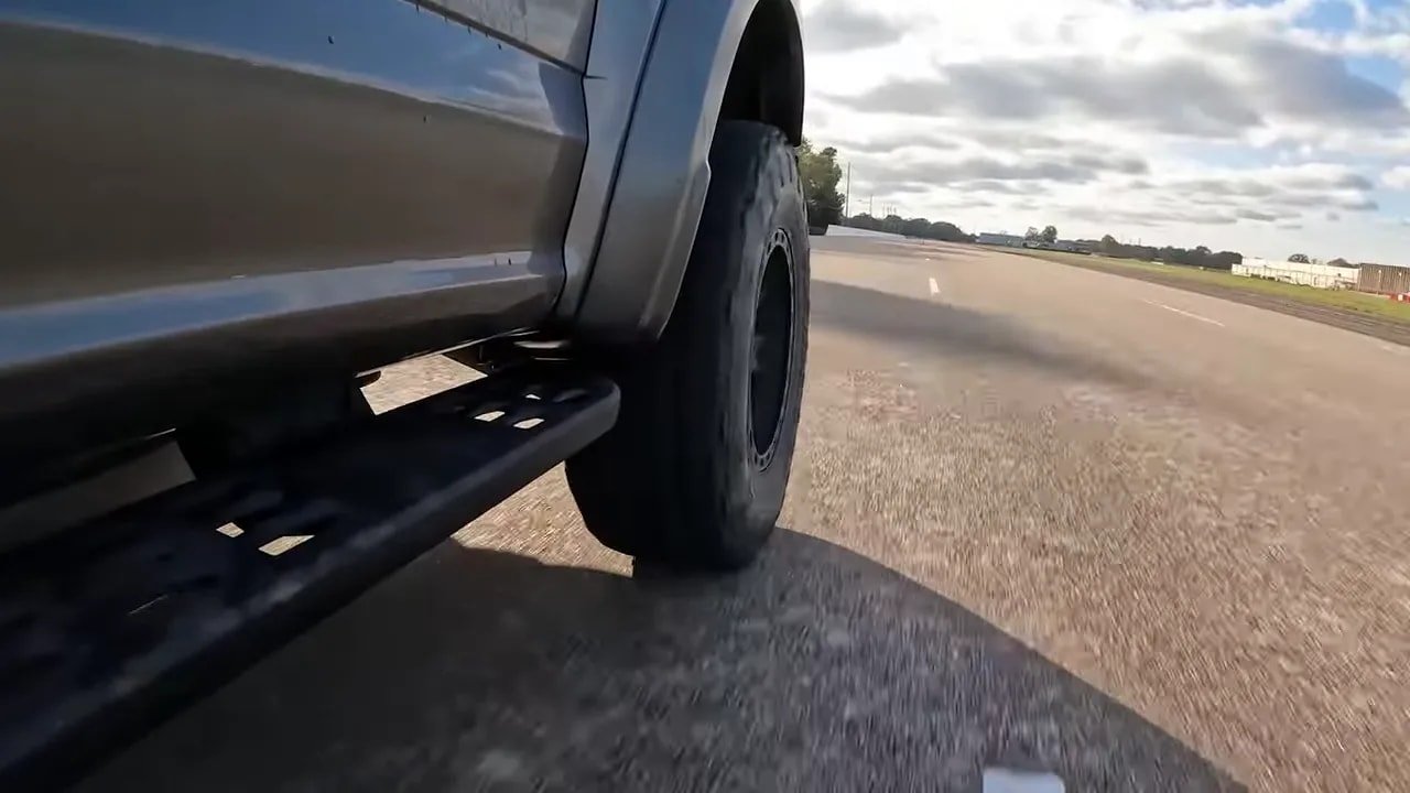 All-terrain tire driving on a paved road to illustrate highway road noise