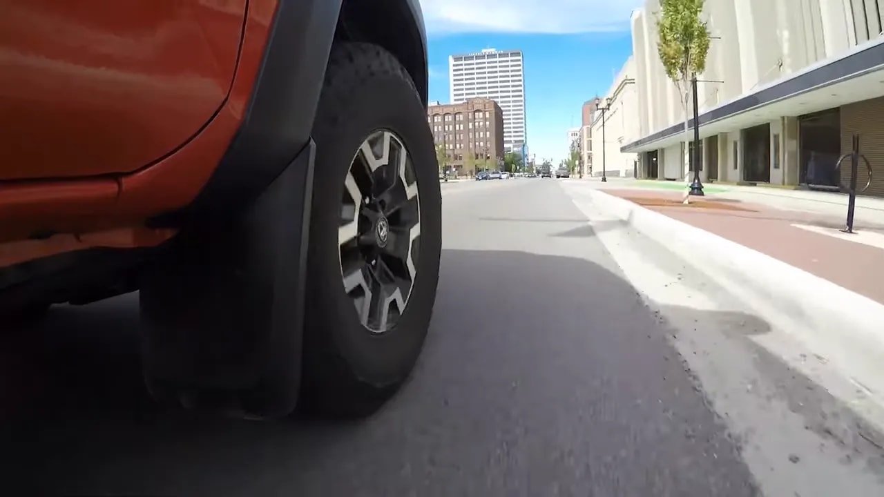All-terrain tire rolling on a paved city street for highway driving