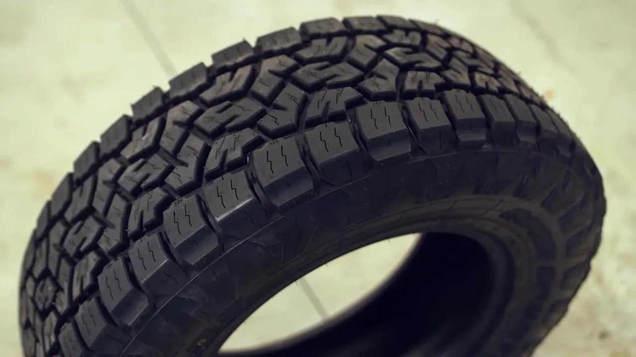 Close-up of all-terrain tire tread blocks and sipes