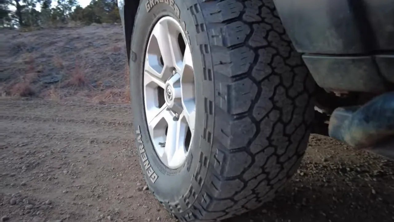 All-terrain tire tread and wheel close-up showing snow and mud-ready pattern