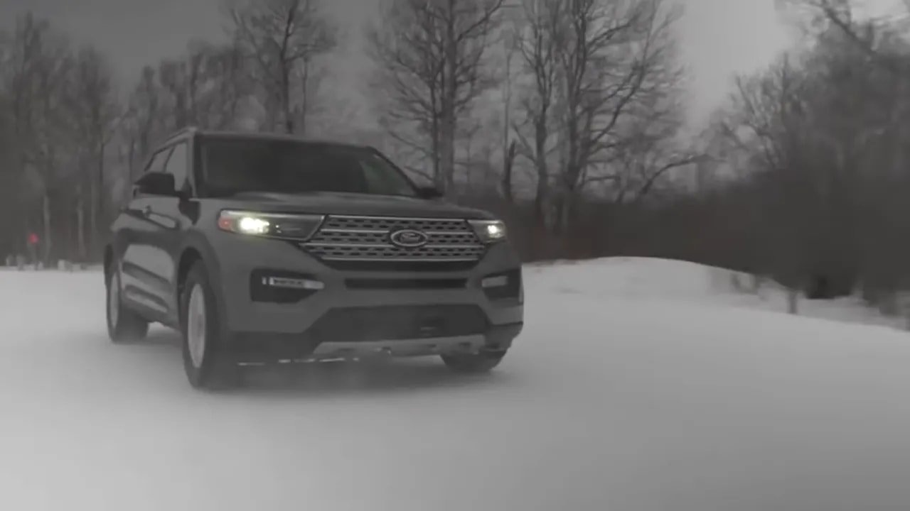 Car driving on snowy road with winter tires in a low-visibility test setting