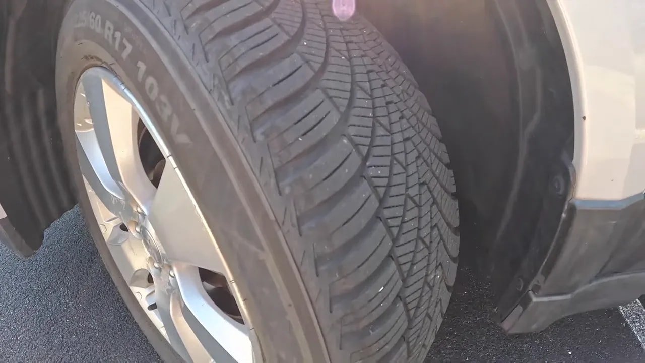 Close-up of all-season tire tread with winter-style sipes and grooves