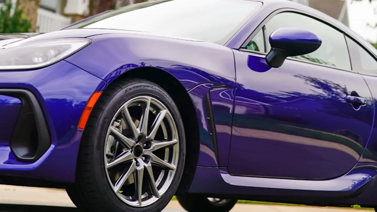 Close-up of a performance tire and wheel on a purple sports car