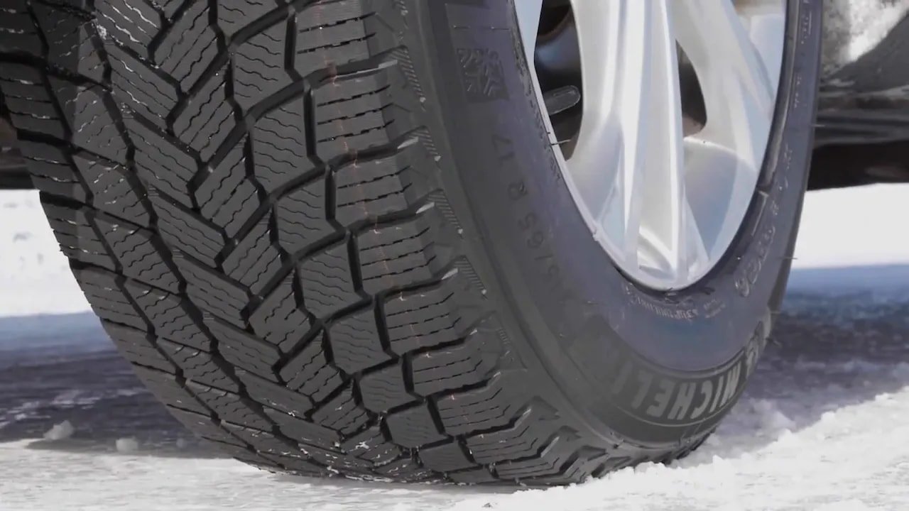 Close-up of studless winter tire tread on snowy ground