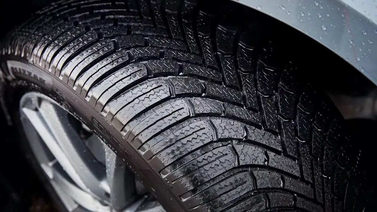 Close-up of winter tire tread blocks and grooves on a snow-ready tire