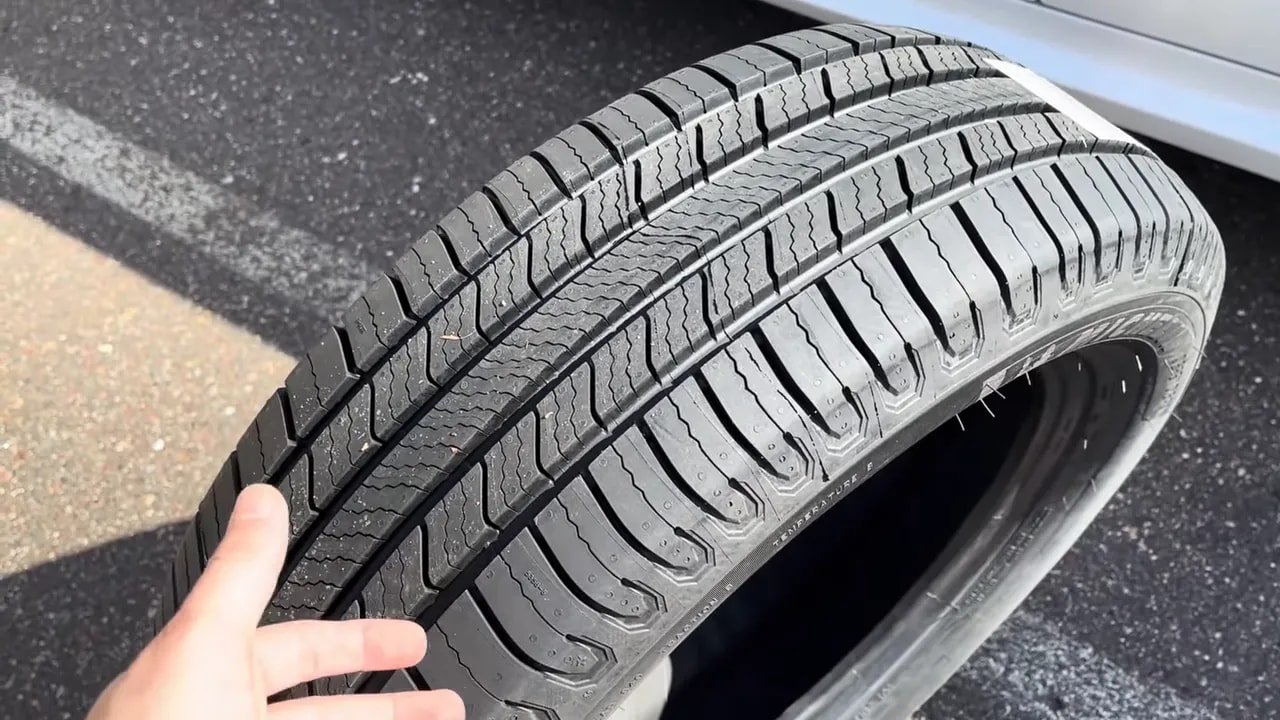 Detailed view of all-season tire tread pattern on pavement
