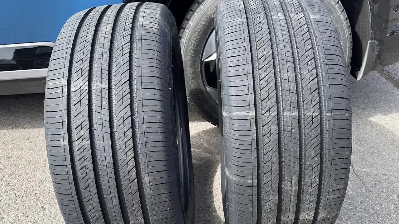 Close-up tread view of two electric vehicle tires on a road surface