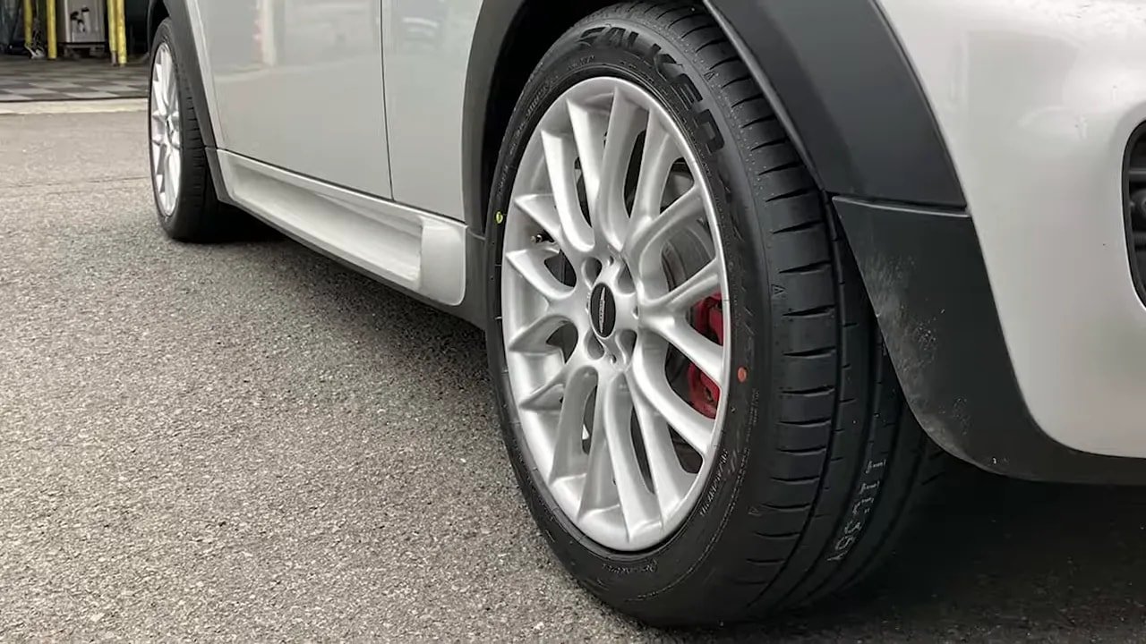 Performance summer tire installed on a car wheel in an outdoor parking area
