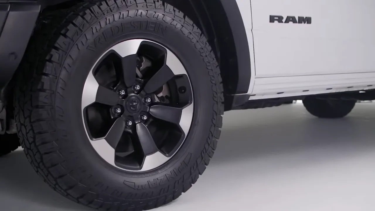 All-terrain tire and wheel on a truck with tread and shoulder detail