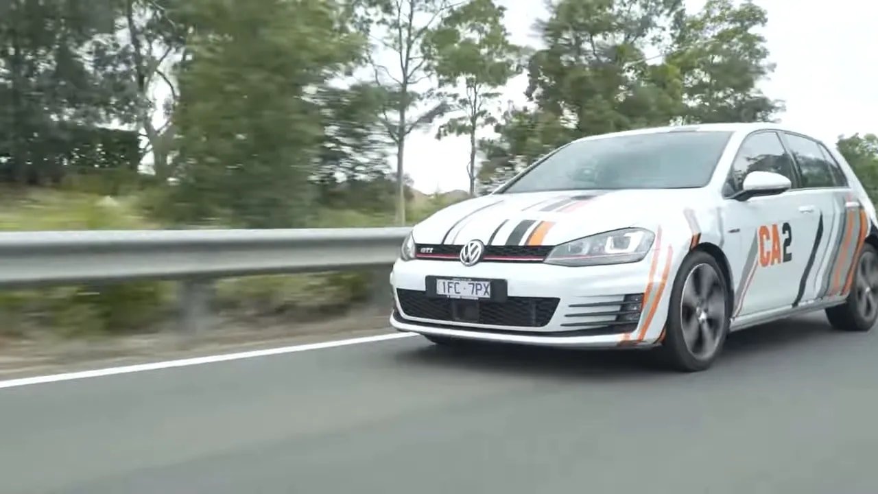 Race-ready sedan on a wet track demonstrating ultra-high-performance summer tire grip