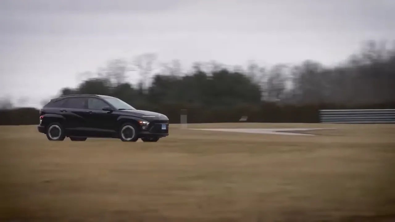 Vehicle driving on a track-like road to demonstrate summer tire performance