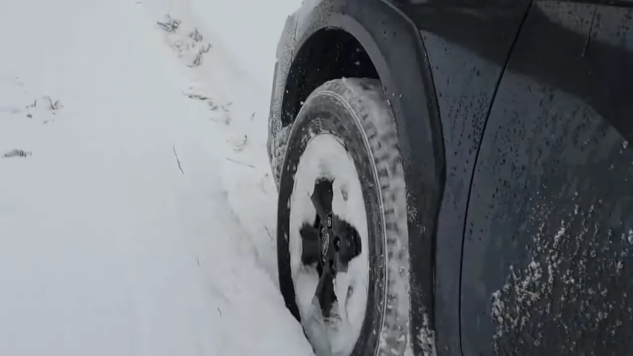 Close-up of a winter tire rolling through deep snow and slush